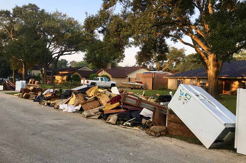 Trash and debris in front of a home after a flood