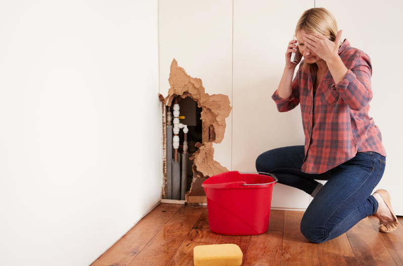 Woman calling a restoration company after water damage