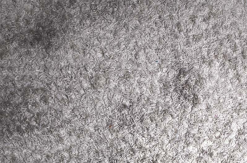 White carpeting with ground-in ash and soot stains.