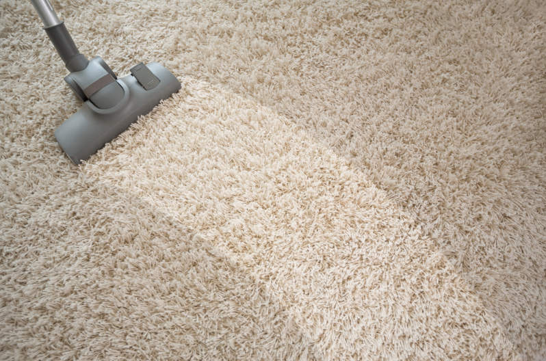 Vacuuming a carpet with musty mildew smells